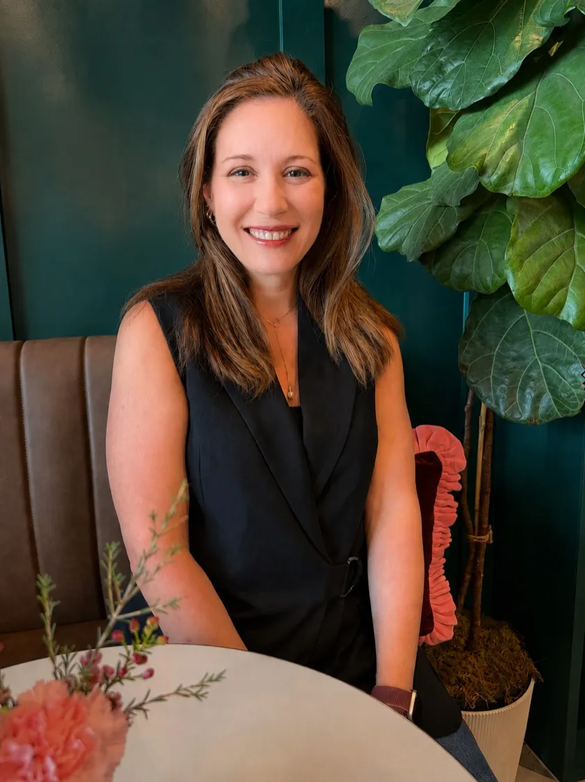 Annie, founder of Well Rooted, smiling in a warm restaurant setting